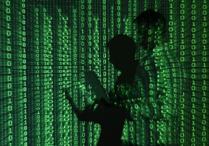 An illustration picture shows a projection of binary code on a man holding a laptop computer, in an office in Warsaw June 24, 2013. REUTERS/Kacper Pempel (POLAND - Tags: BUSINESS TELECOMS)
